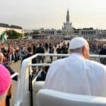 Pope Francis waving to crowds during a public event in Lisbon, Portugal.